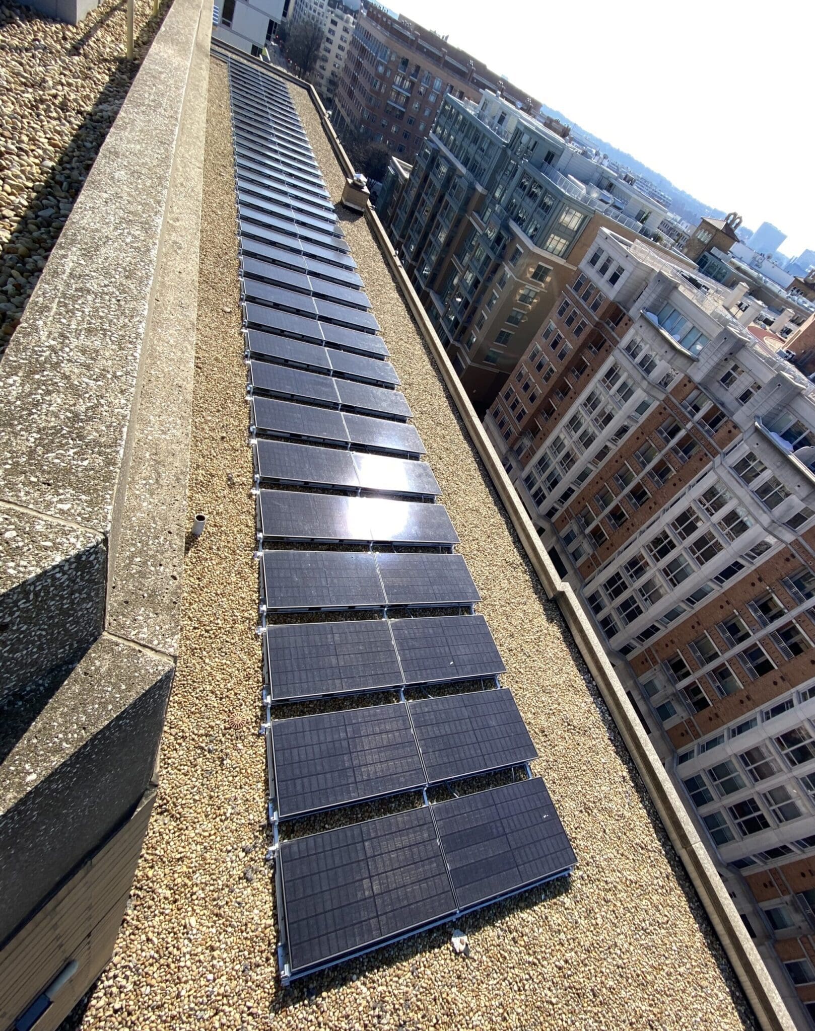 Sun shining on a Georgetown hotel in Washington DC with a rooftop solar array